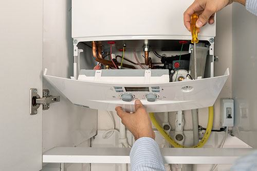 HVAC technician repairing an indoor boiler in Denver