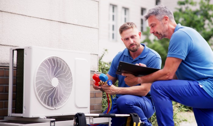 HVAC technicians installing an outdoor air conditioning unit in Denver