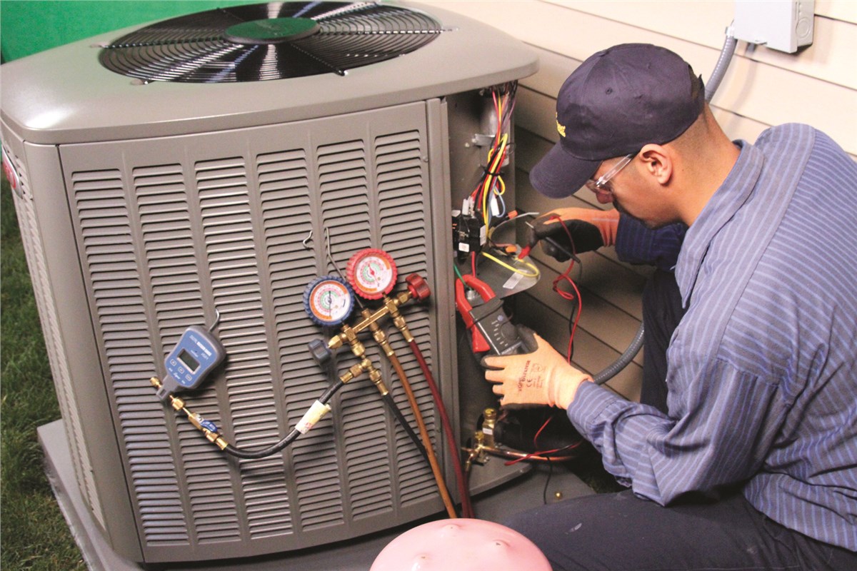 HVAC technician testing an outdoor air conditioning unit in Denver