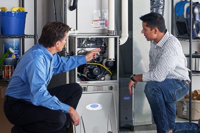 HVAC technician explaining furnace repair and maintenance to a homeowner in Denver, CO