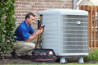 HVAC technician inspecting an outdoor air conditioning unit in Denver, CO